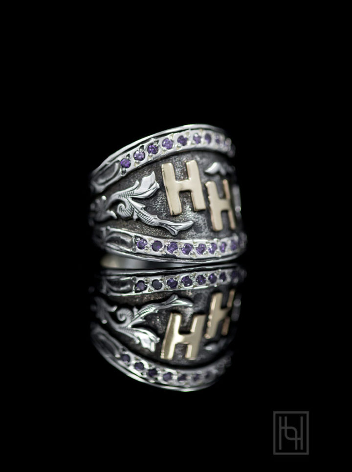 Silver ring - side view with oxidized background, silver scrolls, yellow gold lettering and purple amethyst cz stones