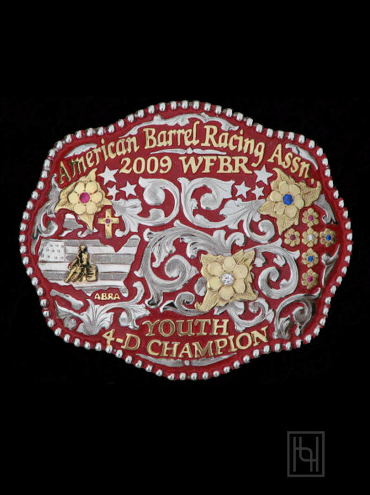 Red background, silver scrolls, yellow gold lettering and flowers, red crystal clear and blue cz stones, barrel racing yellow casted figure