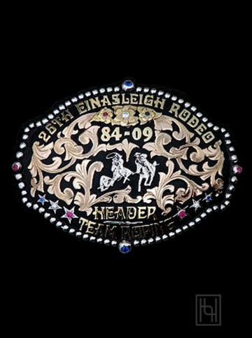 Black background w/ rose gold scrolls, yellow gold lettering and flowers, silver casted team roping figure, red clear and sapphire cz stones