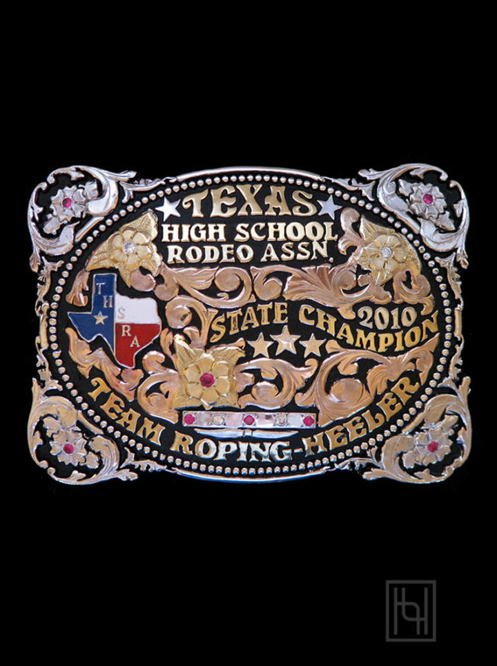 Black background w/ rose gold scrolls, yellow gold lettering and flowers, red white and blue Texas figure, THSRA logo, silver stone bar with ruby sapphire and crystal clear stones