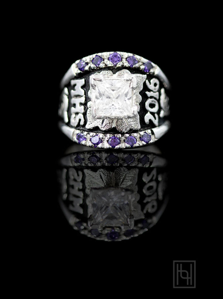 Black background with silver scrolls, leaf and lettering, 7mm square crystal clear cz stone on prong, purple amethyst cz accent stones in edge