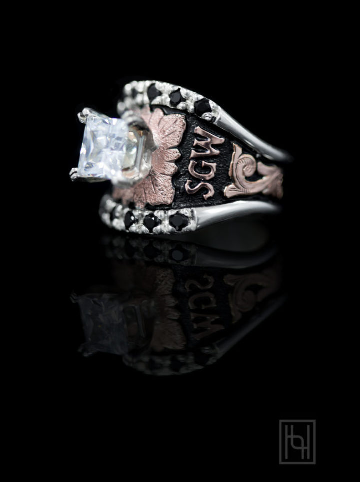 Black background w/ rose gold scrolls, leaf and lettering and 7mm square crystal clear cz stone in setting, blackest black accent stones in edge