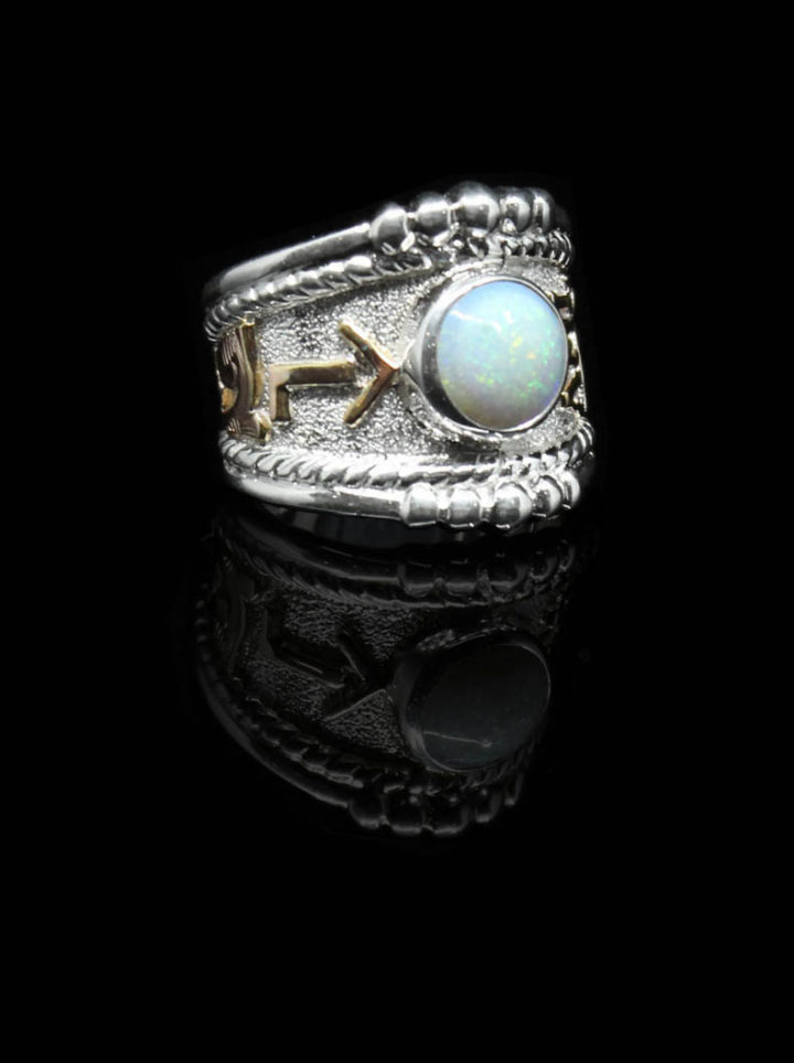 Custom ring with silver background and yellow gold scrolls and brand, 8mm round bezel set created opal stone