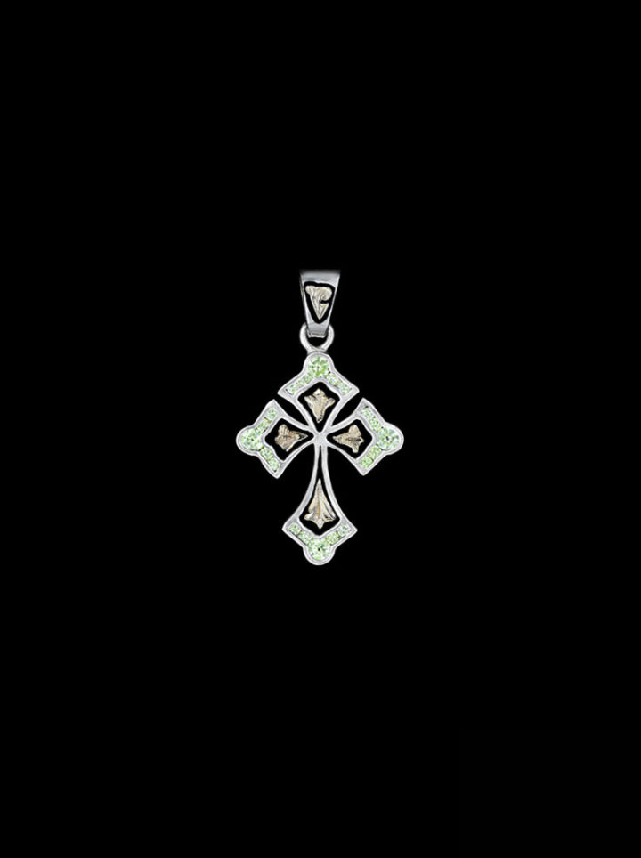 Petite cross w/ flared edges and vibrant peridot green stones in edge w/ a combination of gold scrolls and black background