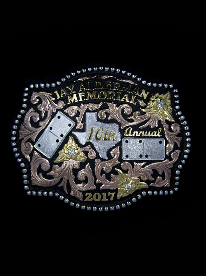 Yukon Custom Buckle beaded edge, black background and rose gold scrolls, yellow gold lettering, silver Texas and domino figures