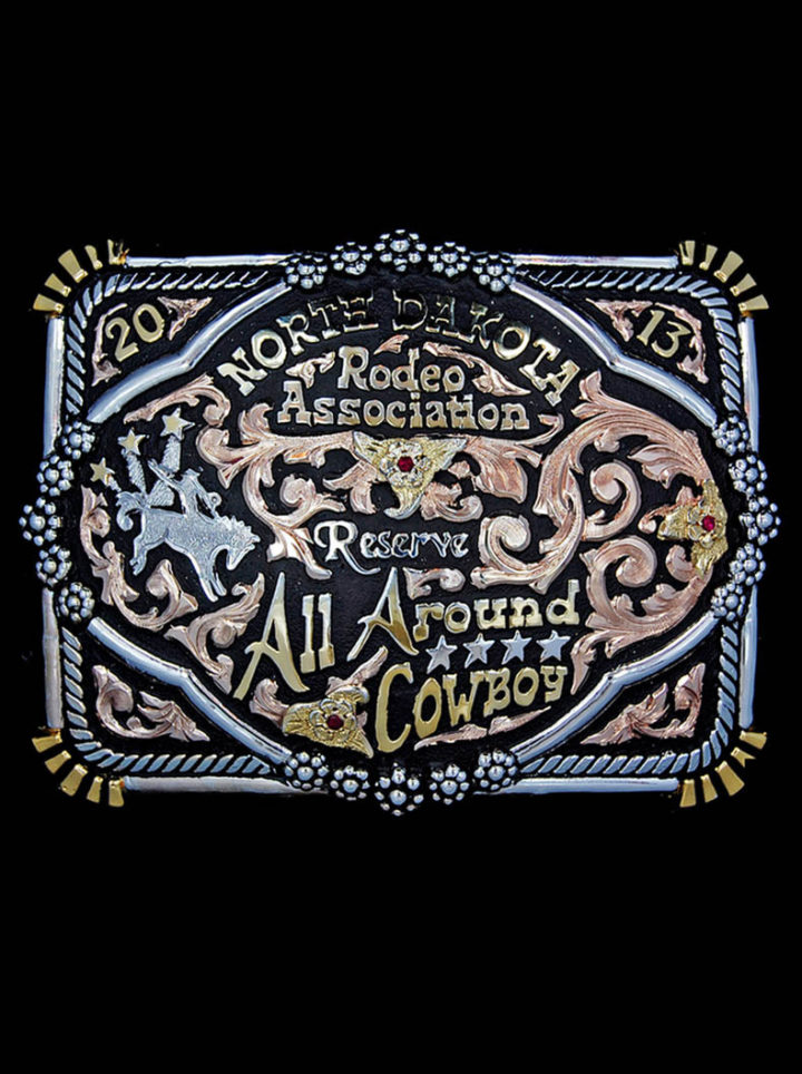 Zephyr Custom Buckle with black background, rose gold scrolls, yellow gold lettering and flowers, silver bucking bronco figure